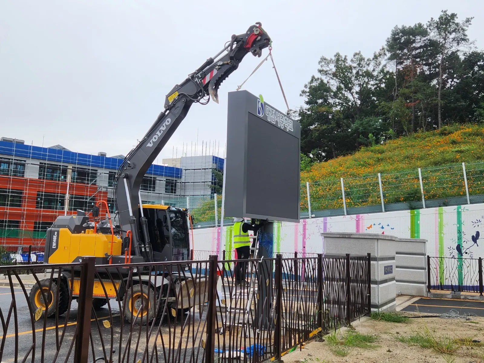 학교 정문 지주형 옥외 LED 전광판 설치 완료 후 정면 모습, 학교 로고와 화면 표시