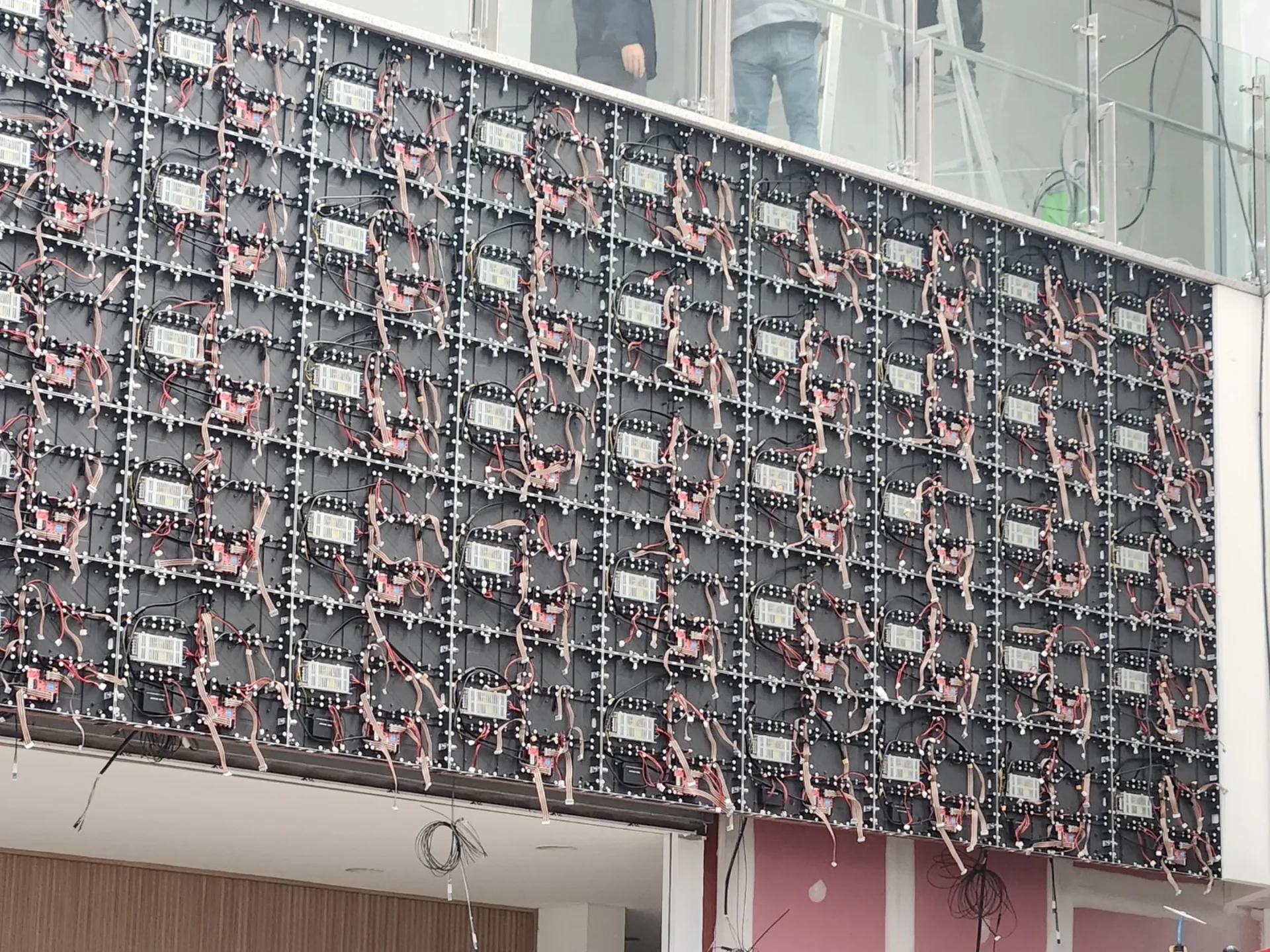 실내 벽면에 설치 중인 대형 LED 전광판 모듈 근접 사진
