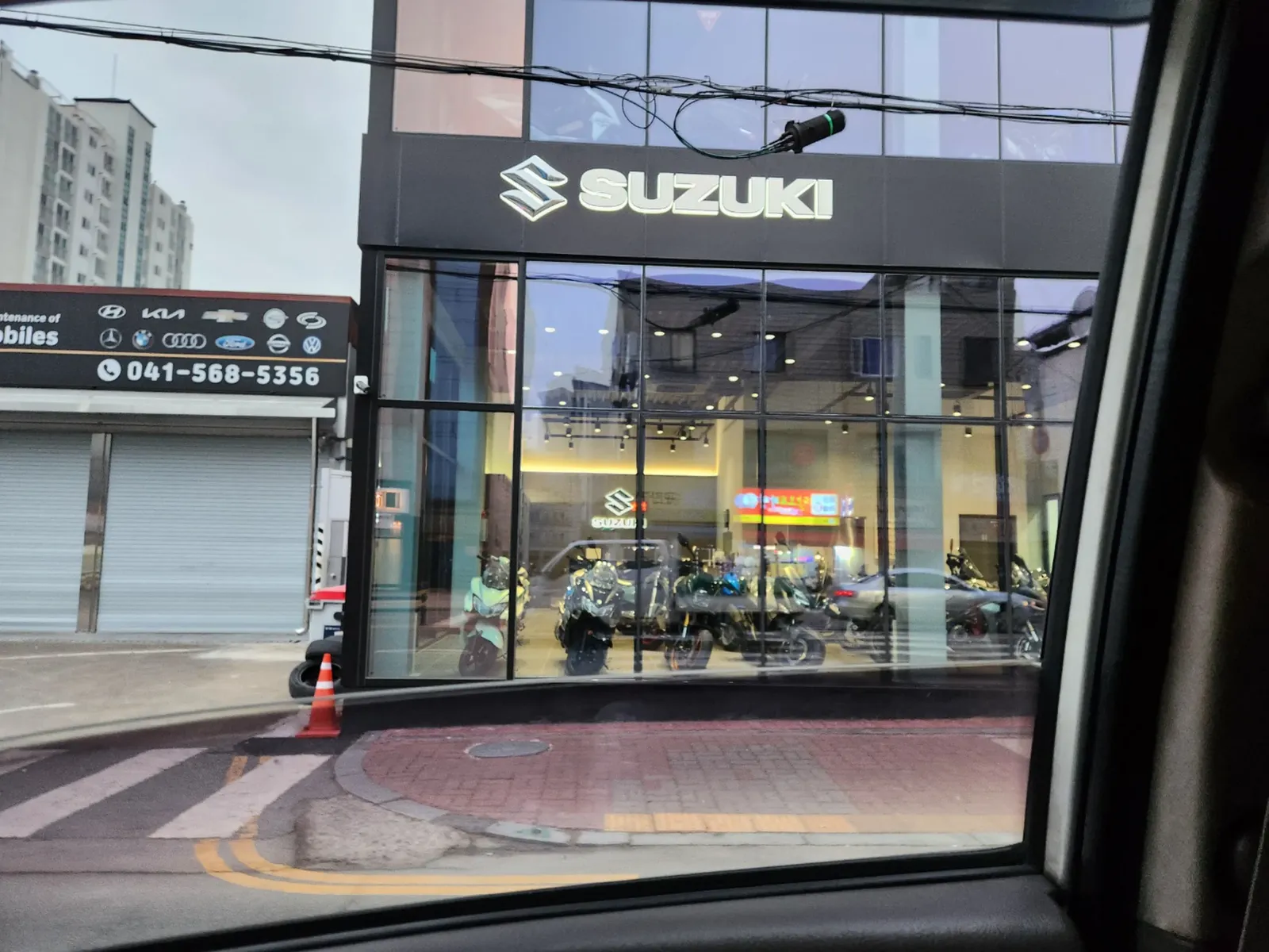 쇼룸 건물 외벽 서비스센터 입구에 설치된 야간 조명 사인과 전광 배너
